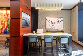 Co-working stations in lobby featuring conference table and large tv
